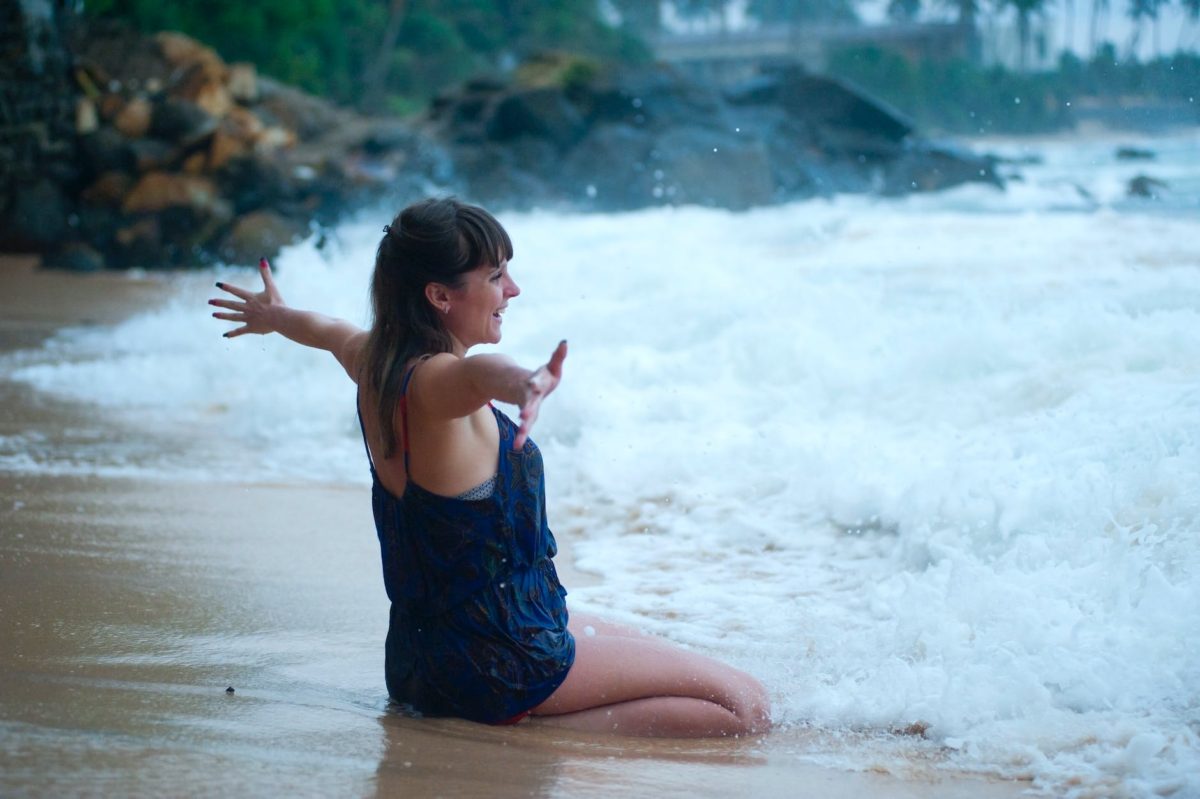 woman kneeling on shoreline